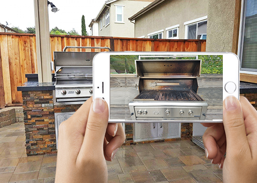 Phone taking a photo of the same built-in grill with the lid open