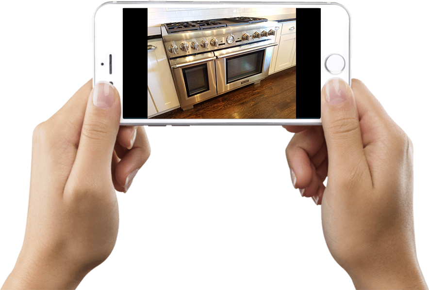 Hands holding a phone with a photo of a whole range and both oven doors closed